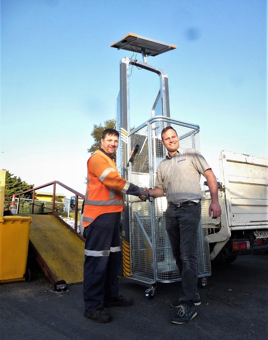 Whangaparaoa Community Recycling Centre site manager Brendan Parris, left, and Simpro’s Daniel Currie with the solar-powered wheelie bin lifter